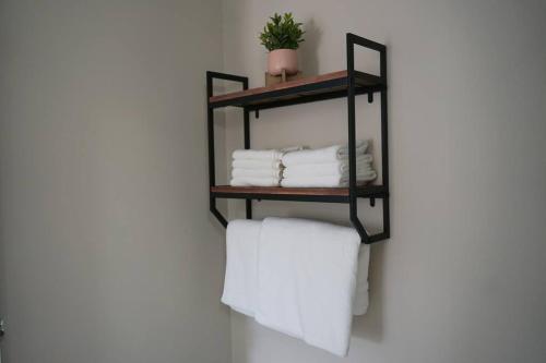 a black shelf with towels on a wall at New Suite 15min from DT Van & Skytrain + Parking in Vancouver