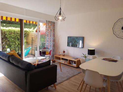 un salon avec un canapé et une table dans l'établissement le Nid des Cèdres, voisin des Thermes et du centre, à Thonon-les-Bains