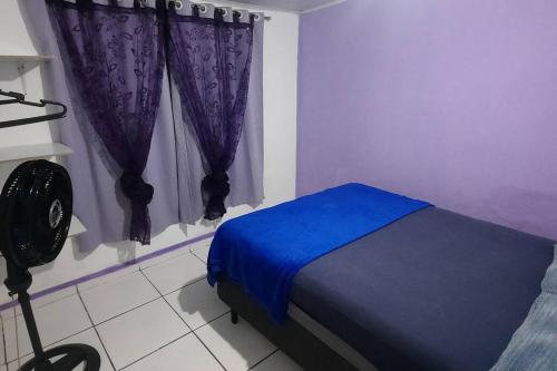 um quarto com uma cama azul e uma janela em Casa dos Sonhos em Campo Grande