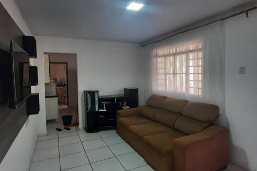 uma sala de estar com um sofá e uma televisão em Casa dos Sonhos em Campo Grande