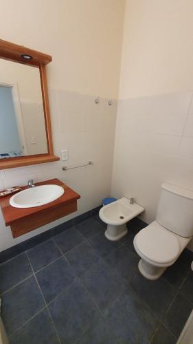 a bathroom with a toilet and a sink and a mirror at Hotel Viola in La Paloma