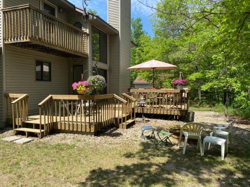 a house with a deck with a table and an umbrella at Adventures @ Cottage on the Bend in Leota