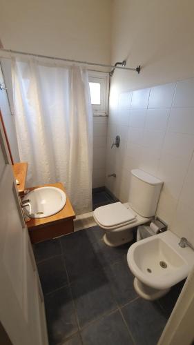 a bathroom with a white toilet and a sink at Hotel Viola in La Paloma