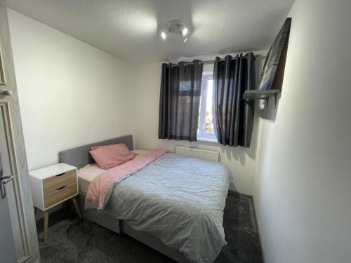 um pequeno quarto com uma cama e uma janela em Bowman’s Place Cosy Lodge em Kent