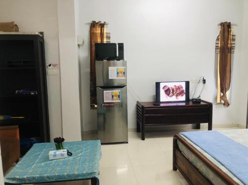 a living room with a refrigerator and a table at Homey Stopover Cherating in Kuantan