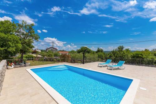 una piscina con 2 sillas azules y un patio en Apartments with a swimming pool Zgaljici, Krk - 21703, en Malinska