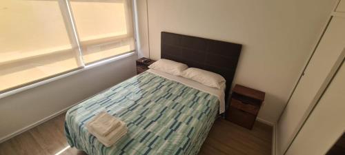 a small bedroom with a bed and two windows at Semipiso 2 Ambientes Cuba 3812 Nuñez in Buenos Aires