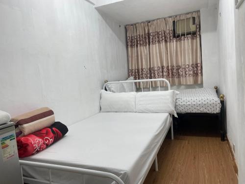 a small room with two beds and a window at Relaince international guest house in Hong Kong