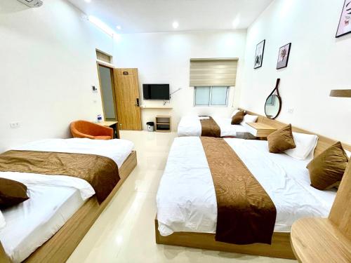 um quarto de hotel com duas camas e uma televisão em GREEN HOTEL em Cao Bang