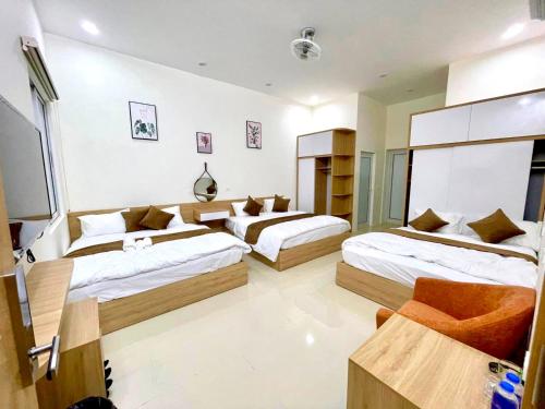 a bedroom with two beds and a couch at Green Hotel Cao Bằng in Cao Bằng