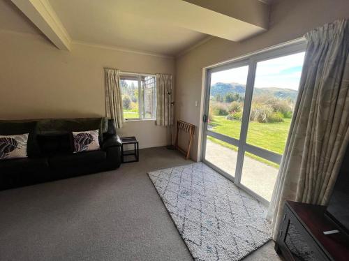 a living room with a couch and a large window at Two Bridges Tekapo in Lake Tekapo