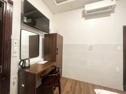a room with a desk with a mirror and a sink at Motel Mỹ Vân in Cái Răng
