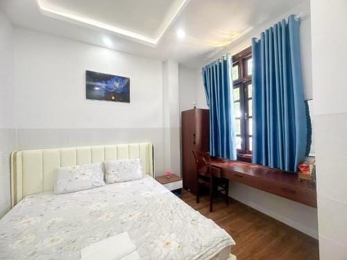 a bedroom with a bed and a desk and a window at Motel Mỹ Vân in Cái Răng