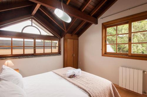 una camera con un letto e due finestre di LOCAR-IN GRAMADO - Duplex Solar da Borges a Gramado