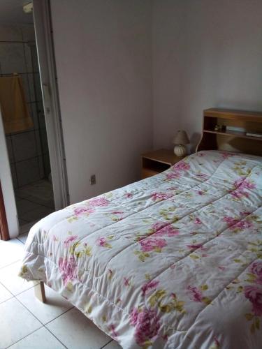 聖若澤杜斯坎普斯的住宿－Casa SFX Centro，一间卧室配有一张带花卉棉被的床