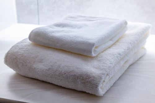 tre asciugamani impilati l'uno sopra l'altro su un bancone di 淡路島 Villa Paddle - Self Check-In Only a Sumoto