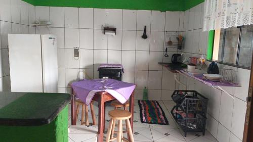 uma pequena cozinha com uma mesa e um frigorífico em Doce Lar - 1 suíte em Tangará da Serra