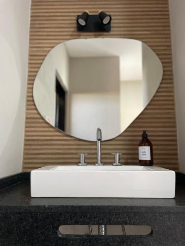 a bathroom sink with a large mirror above it at La Morada Almafuerte in Almafuerte
