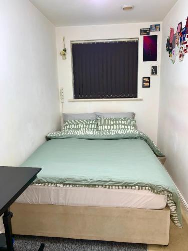 a bed in a small room with a window at Private Room in shared Apartment Free Parking -20min to Manchester in Manchester