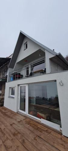 a white house with a large sliding glass door at Chata u Jančúra in Vinné