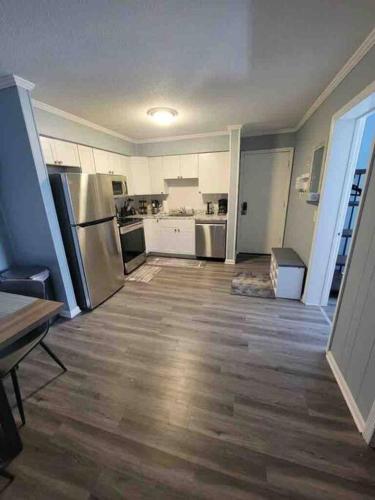 a large kitchen with stainless steel appliances and wooden floors at 2022 Renovated 2-bdrm cozy, lovely condo w/parking! in Hilton Head Island