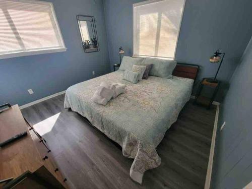 a bedroom with a large bed with blue walls at 2022 Renovated 2-bdrm cozy, lovely condo w/parking! in Hilton Head Island