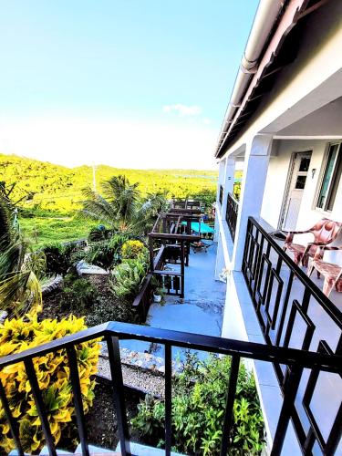 a balcony of a house with a view of a yard at Ellen Bay Inn in Saint Philips