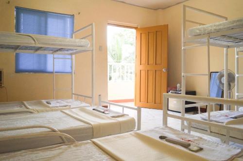 a room with three bunk beds and a door at Hana-Natsu Resorts Pool & Hotel in Maybayo