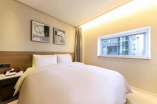 Un ou plusieurs lits dans un hébergement de l'établissement Ocean 2Heaven Hotel Busan
