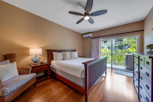 a bedroom with a bed and a couch and a window at Poipu Kai - Koloa, HI in Koloa