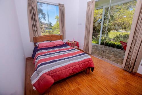 1 dormitorio con cama y ventana grande en La Casa de Luiz - Casa de Campo, 