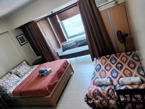 een kleine kamer met een bed en een raam bij Rqui CondoTel Near Airport in Manilla