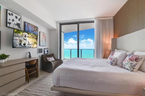 Un dormitorio con una cama y un escritorio y una ventana. en Luxurious 2 bedroom on the Ocean at Lyfe Resort, en Hollywood