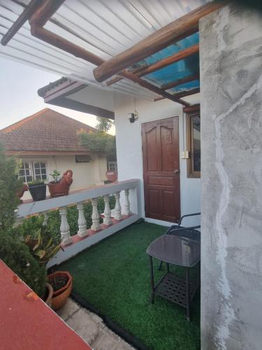 a patio with a wooden pergola and green grass at Hom Baan Chiang Mai in Chiang Mai