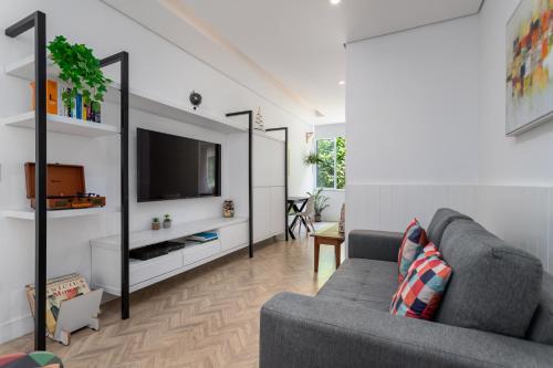 sala de estar con sofá y TV en Fantastic sea view - Maison Ipanema Prime, en Río de Janeiro