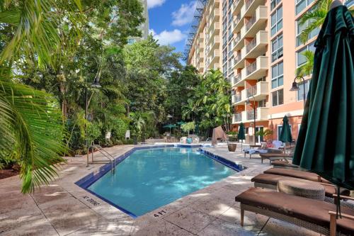 a swimming pool in front of a building at Treetop Retreat! Cozy 2 Bedroom In Heart Of Grove in Miami