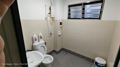 a small bathroom with a toilet and a shower at 3 Rooms Apartment - Near Beach in Kampong Sungai Udang