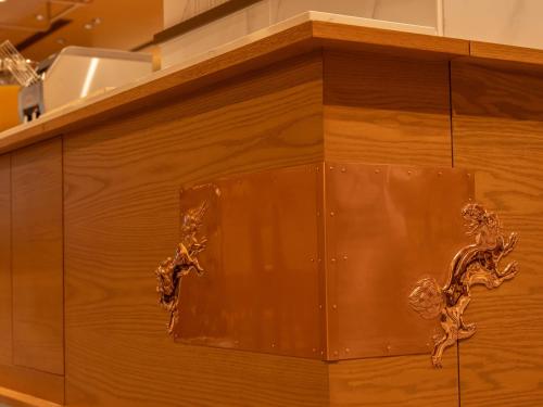 a wooden cabinet with a metal design on it at Loisir Hotel Kyoto Toji in Kyoto