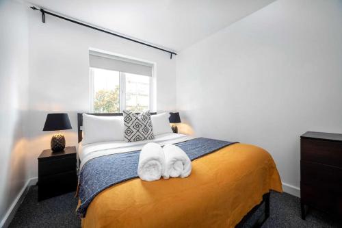 une chambre avec un lit avec deux serviettes dessus dans l'établissement A Stylish One-Bedroom Next to London Museum!, à Colindale