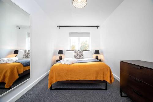 1 dormitorio con 2 camas y espejo en A Stylish One-Bedroom Next to London Museum!, en Colindale