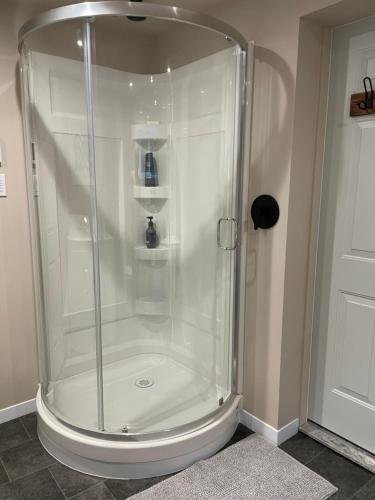 a shower with a glass enclosure in a bathroom at Chalet KLS Lac D'Argent in Eastman