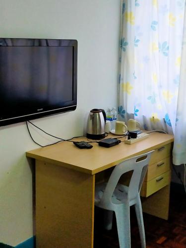 a desk with a television and a table with two chairs at R2L5Y Room 3 with aircond + TV( share Toilet only) in Bentong