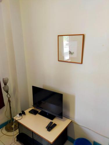 a room with a desk with a flat screen tv at R2L5Y Room 2 in Bentong