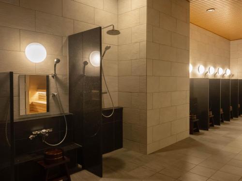 a bathroom with a shower with a mirror and stalls at Loisir Hotel Kyoto Toji in Kyoto