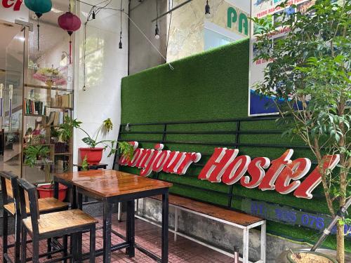 a restaurant with a table and a green bench at Bonjour Hostel in Hue