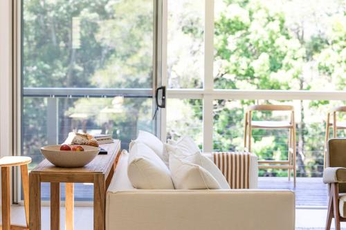 a living room with a white couch and a large window at Friday Hut Fields in Tintenbar