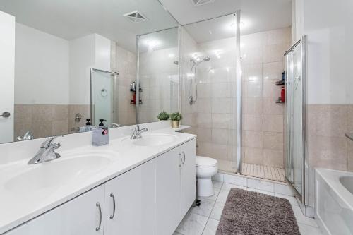 een badkamer met een wastafel, een douche en een toilet bij Spacious Lakefront Condo+Parking+Pool+Gym+Patio in Toronto