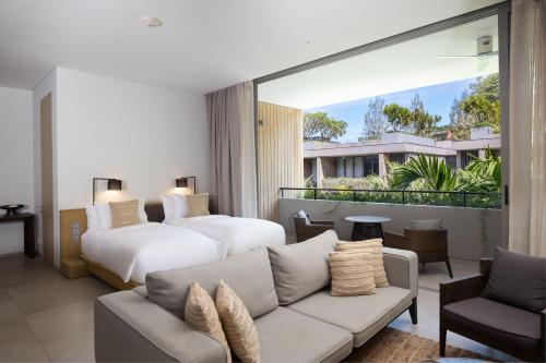 カマラビーチにあるTwinpalms MontAzure Phuketのリビングルーム(ベッド2台、ソファ付)