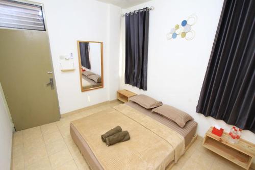 Schlafzimmer mit einem Bett und einem Spiegel in der Unterkunft Athala homestay syariah in Yogyakarta