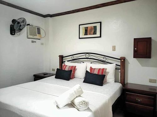 ein Schlafzimmer mit einem großen weißen Bett mit Kissen in der Unterkunft Double Diamond Inn Guest House in Boracay
